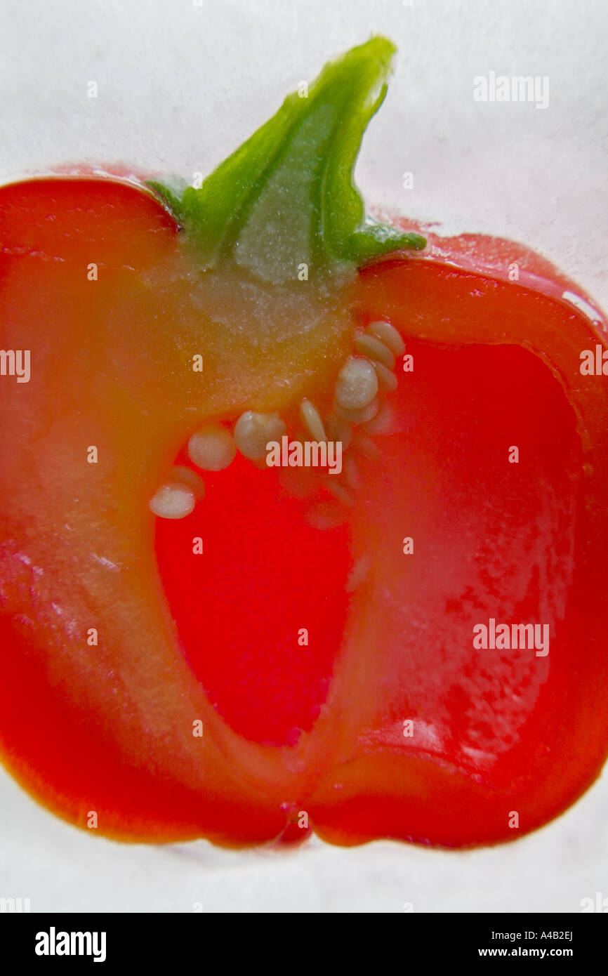 Nahaufnahme einer Paprika-Hälfte, die das Innere mit zeigt Samen im Eis eingefroren Stockfoto