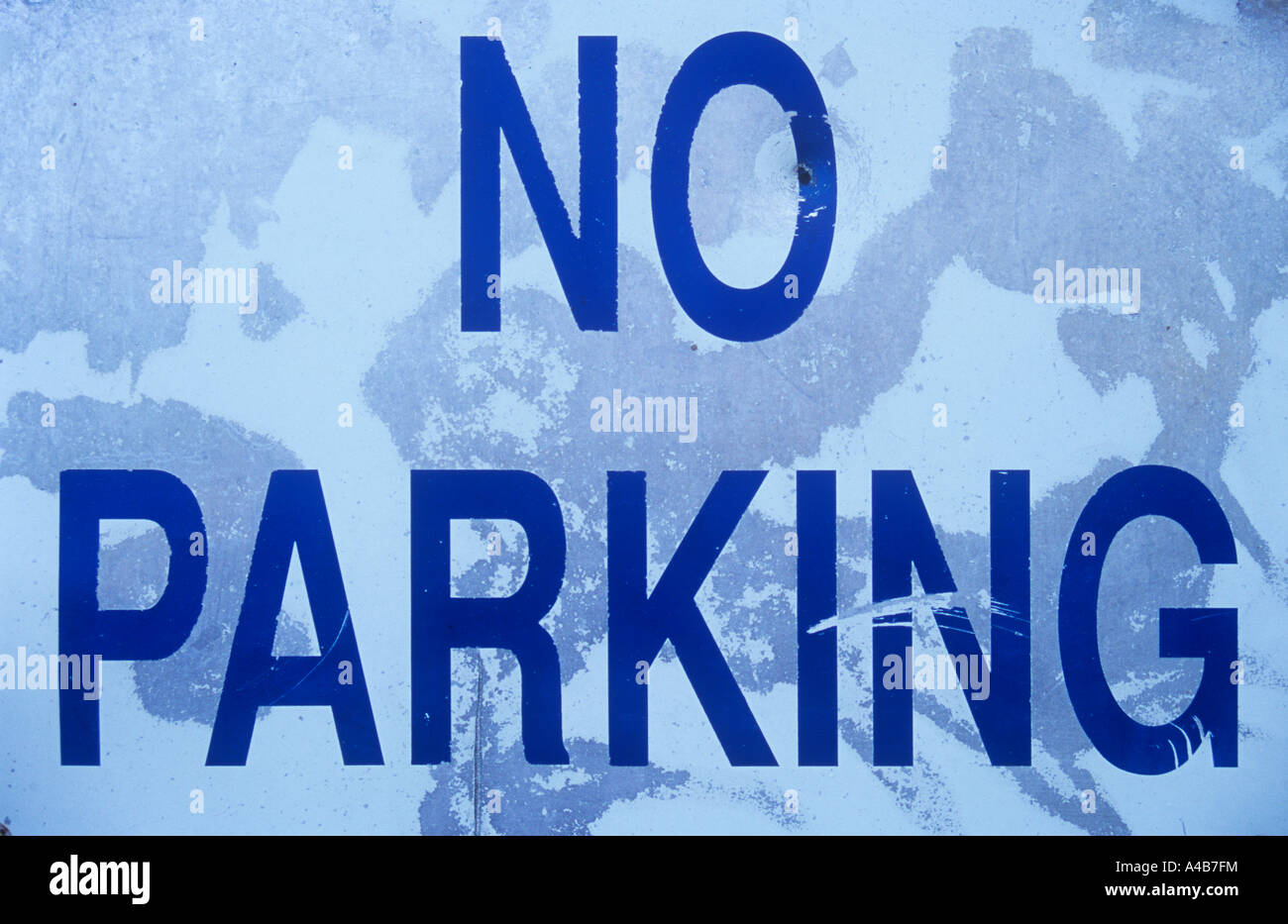 Nahaufnahme von weiß, blau und grau verwittert Blechschild besagt keine Parkplätze Stockfoto