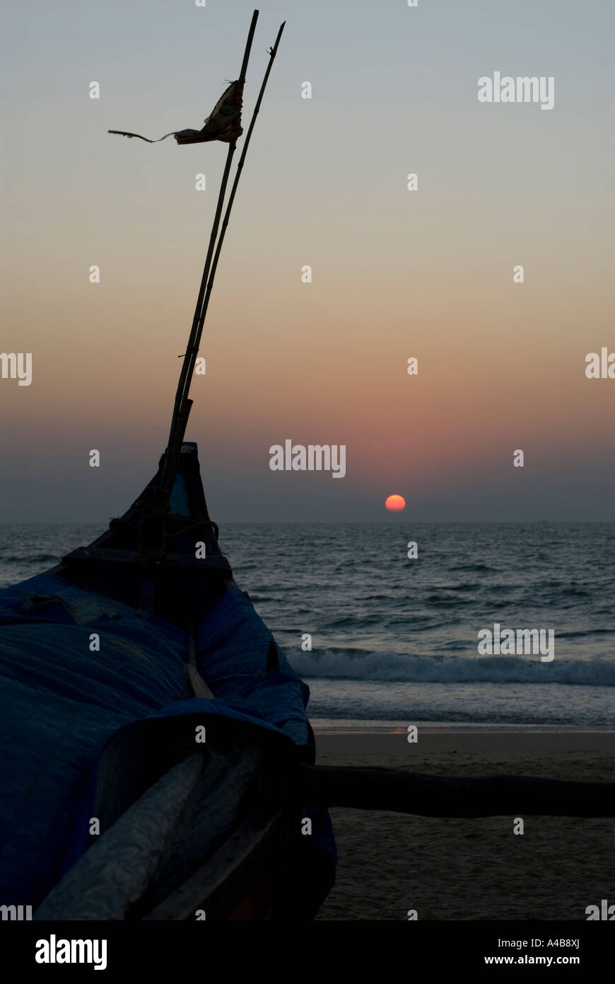 Stock Bild von Benaulim Beach in Goa Indien bei Sonnenuntergang mit Angeln Boot Silhouette und Flagge Stockfoto