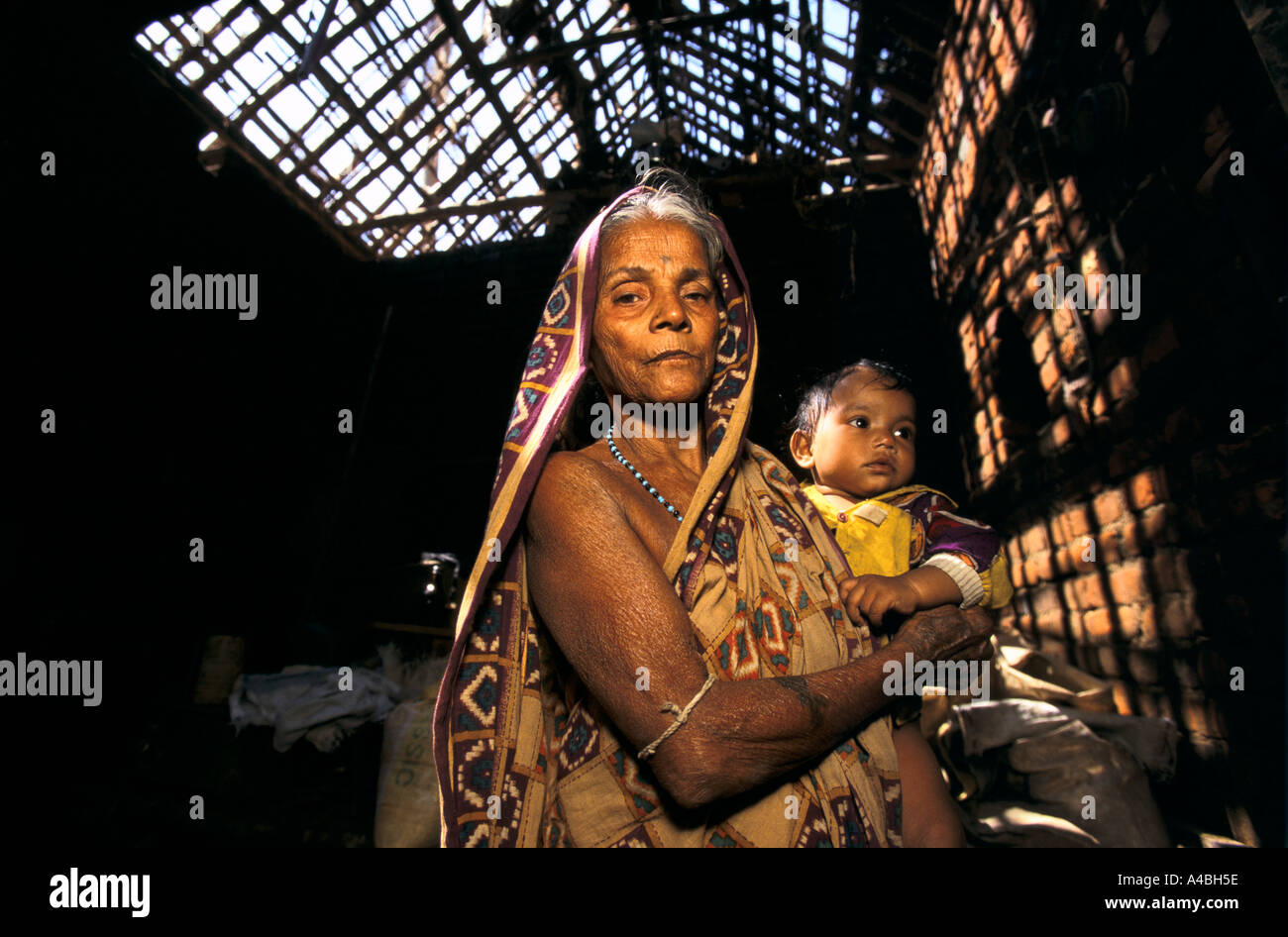 Orissa Wirbelsturm, Indien, 1999: diese Frau hält ihre Enkelin im Inneren ihres Hauses-das Strohdach durch den Zyklon zerstört Stockfoto