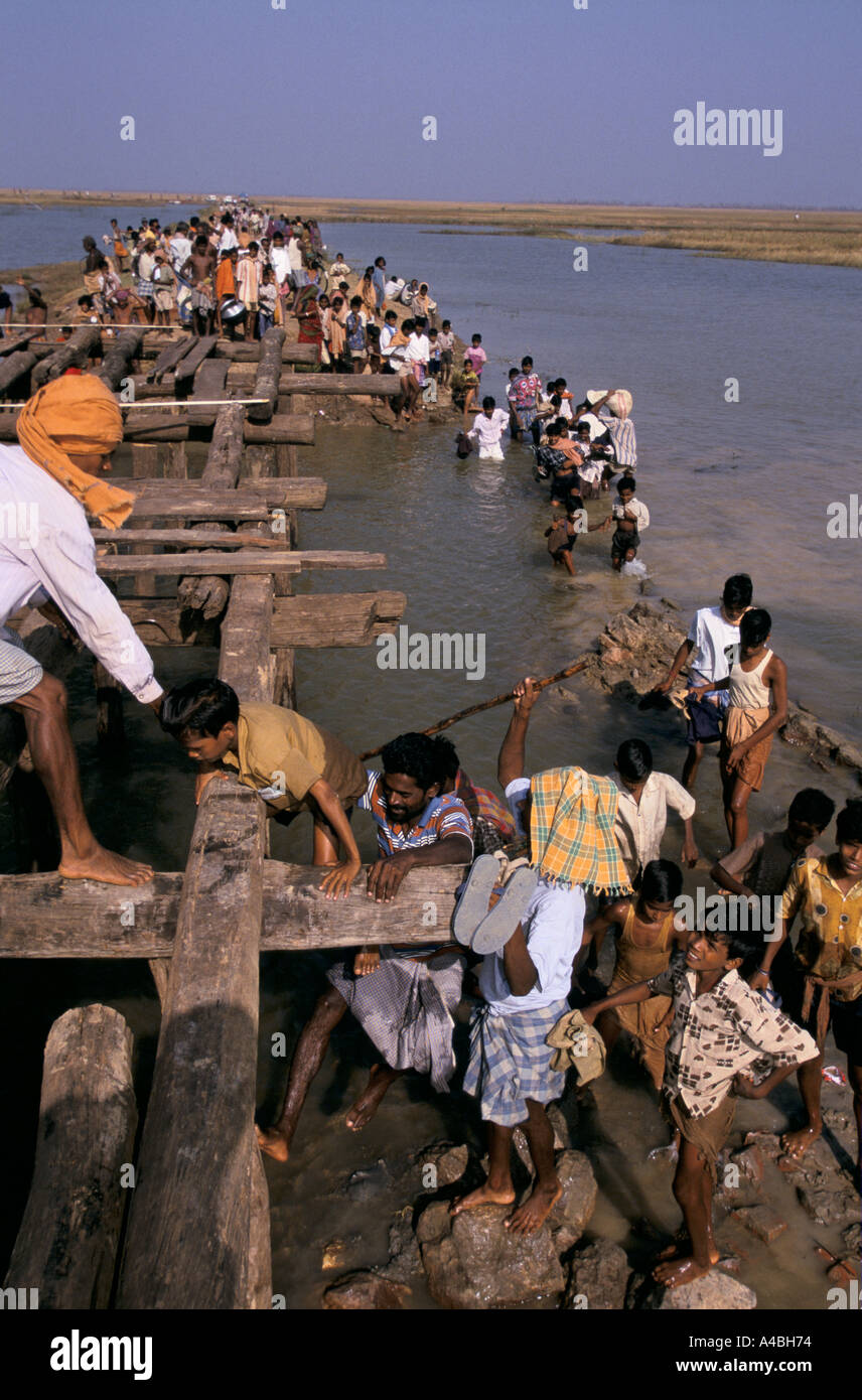 Orissa Wirbelsturm, Indien, 1999: Menschen abgeschnitten durch eine beschädigte Brücke in Erasma Block Aufstieg über eine Verteilung von Nahrungsmitteln zu erreichen. Stockfoto