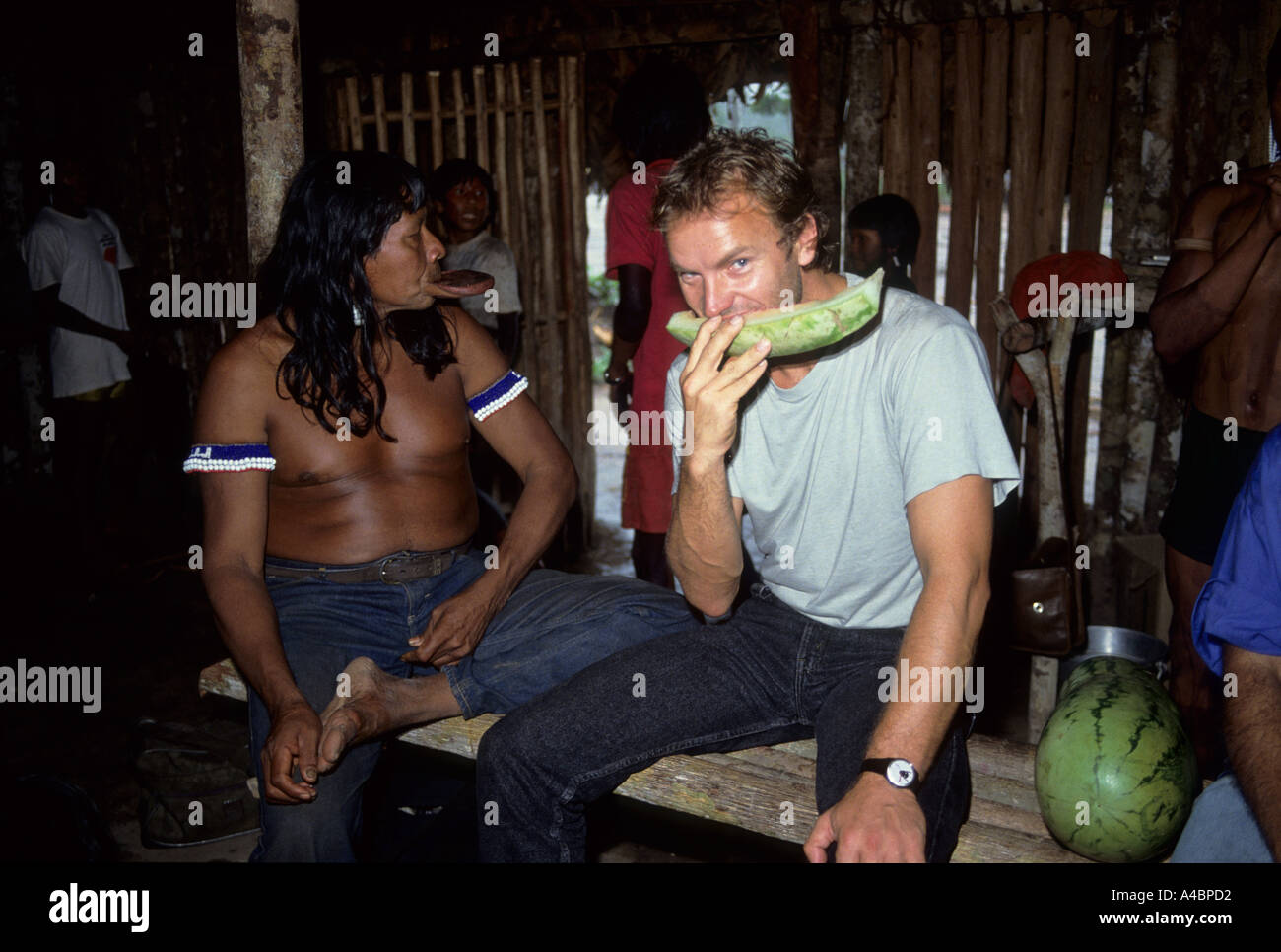 Capoto Dorf, Brasilien. Sting Essen Wassermelone mit Chief Raoni von der Megranoti-Kayapo, November 1990. Stockfoto