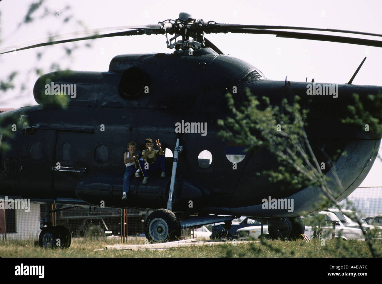 "SERBEN, DIE", KINDER, DIE SERBISCHE SALUTE/ZWEIGEFINGERTE FRIEDENSZEICHEN BEIM SPIEL AUF DEM MILITÄRHELECOPTER IM SOCOLITZ KRANKENHAUS MACHTEN, BRACHTEN IM SEPTEMBER 1992 SCHWERE FÄLLE NACH BELGRAD Stockfoto