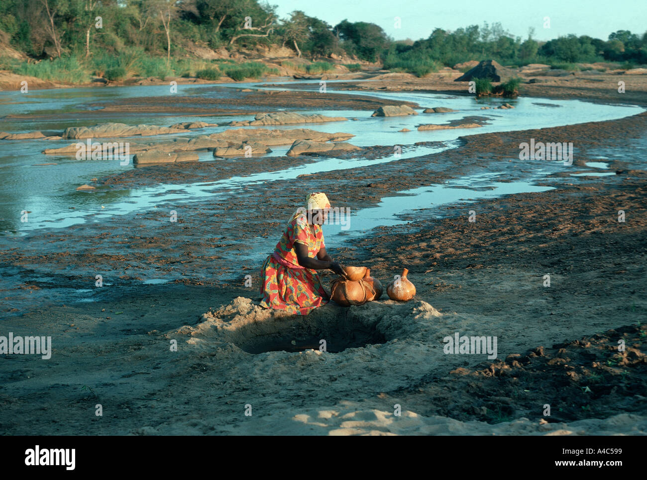 Sammeln von Wasser an einem Wasserloch am Fluss Athi Kamba Frau Stockfoto