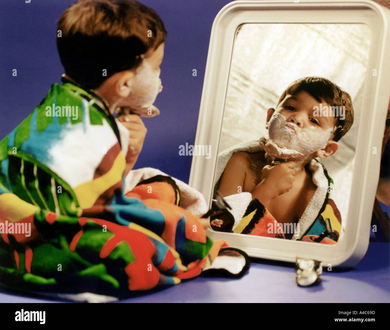 Ein kleiner Junge Praktiken rasieren vor dem Spiegel Stockfoto