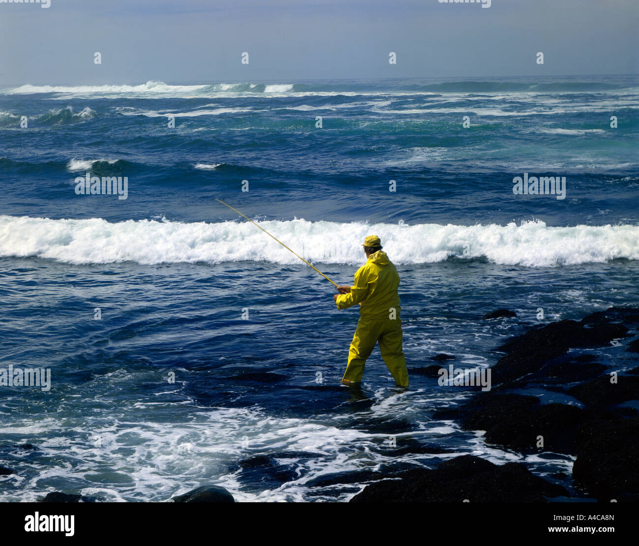 Surf-Fischer steht die mächtigen Wellen des Pazifischen Ozeans entlang der felsigen Küste von Oregon Stockfoto