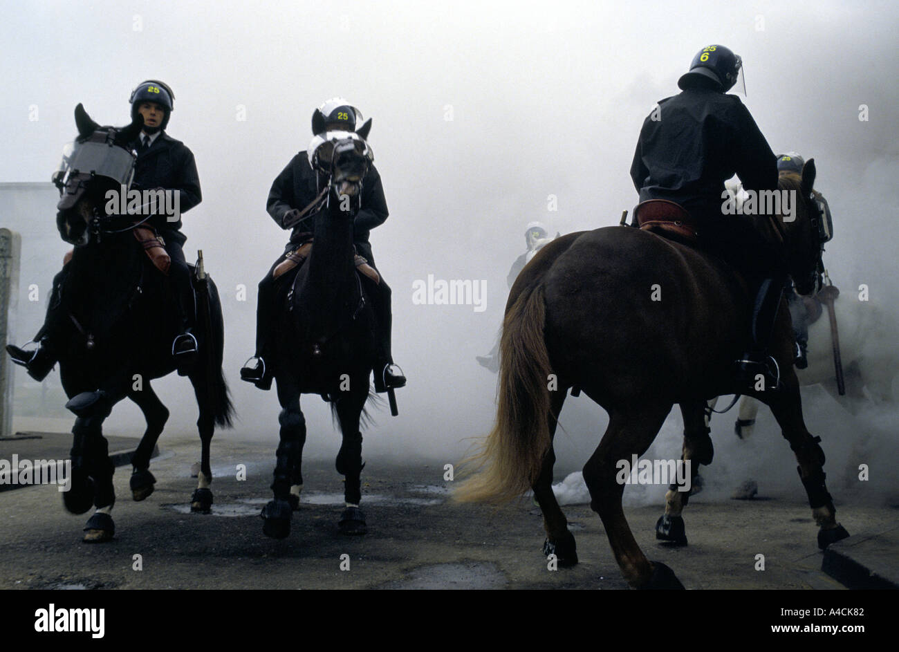 Berittene Polizei Reiten ihre Pferde durch Rauch Fackeln im Rahmen von Riot Training zu steuern Stockfoto