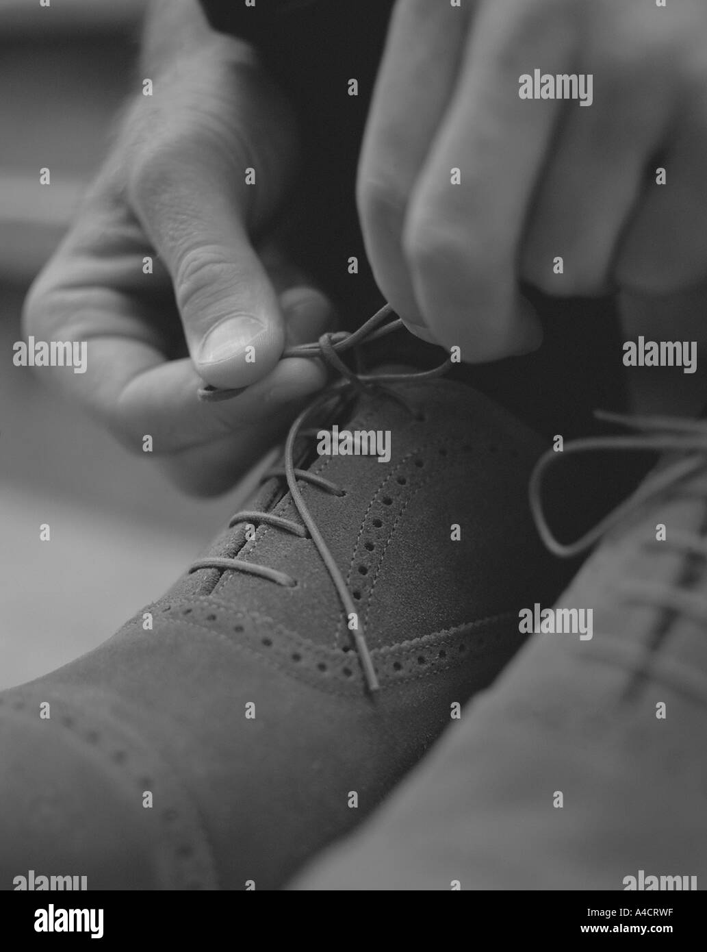 Nahaufnahme Detail des Mannes, die Schnürsenkel zu binden, auf smart casual Schuhe in schwarz und weiß Stockfoto