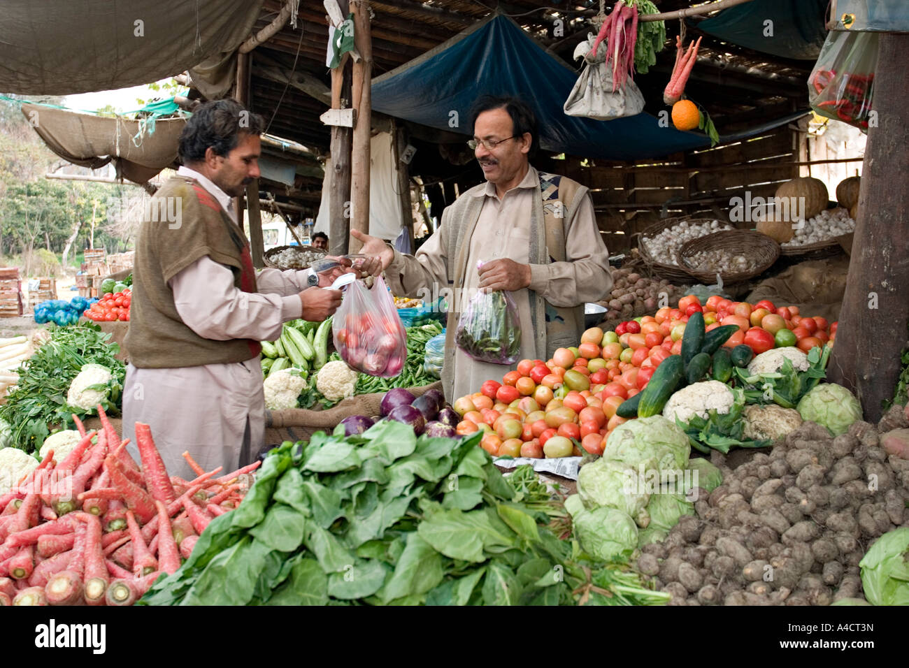 Mann verkauft Gemüse auf einem Marktstand in Pakistan Stockfoto