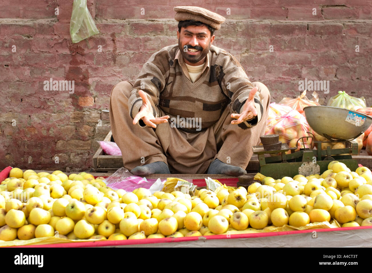 Mann verkauft Äpfel an einem Marktstand in Pakistan Stockfoto