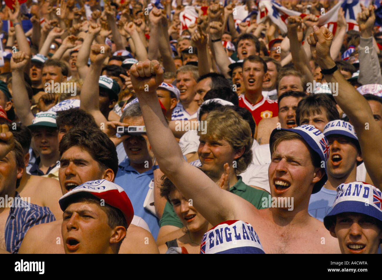 Eine Masse der englischen Fußball-Fans jubeln mit erhobenen Fäusten im Stadion während eines Spiels für den European Cup 1988 Stockfoto