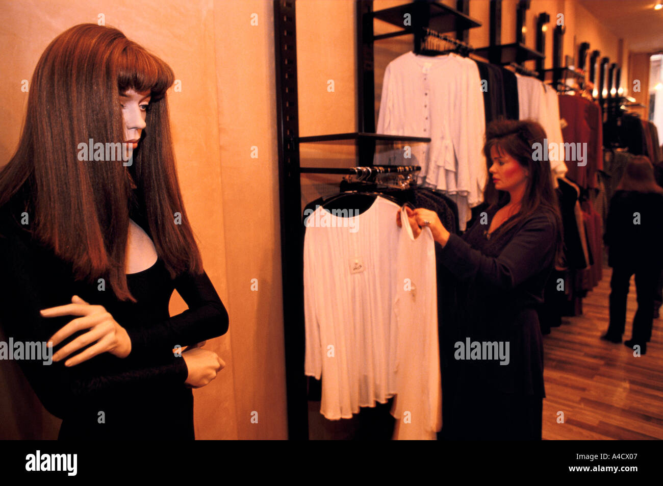 Eine lebensechte Manaquin steht in sich gekehrt Haltung als eine Frauen-Geschäfte in einem Bekleidungsgeschäft an der Lakeside Shopping Centre, Kent Stockfoto
