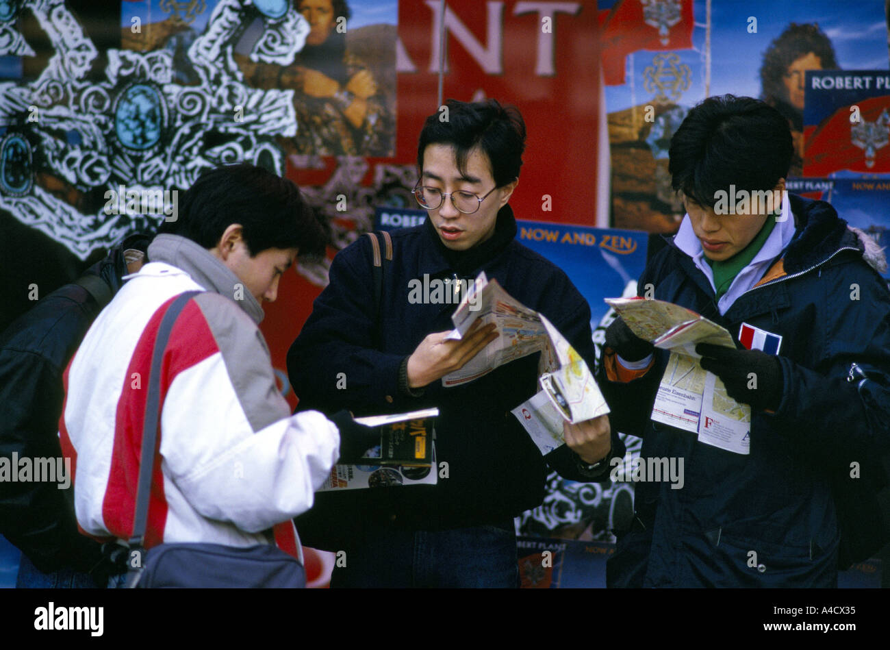 JAPANISCHE TOURISTEN ÜBERPRÜFUNG REISEFÜHRER & KARTEN AUF STRAßE VON LONDON, ENGLAND Stockfoto
