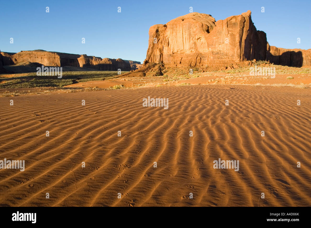 Bauformen in den Sand vor dem Hintergrund einer Sandstein-Mesa im südlichen Teil des Monument Valley Stockfoto