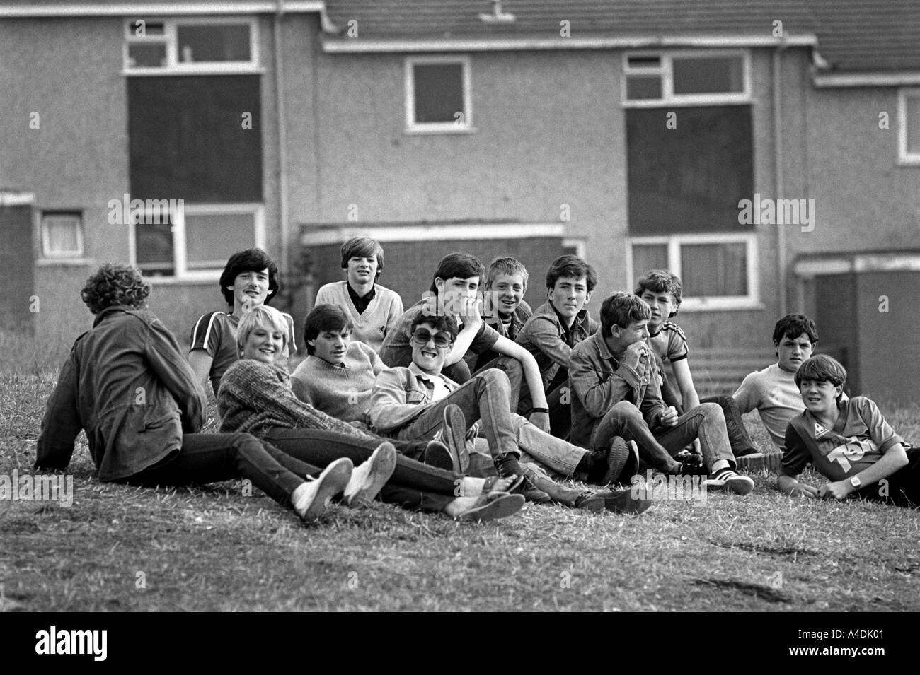 Jugendliche, die auf einer grasbewachsenen Kante auf dem Ford-Estate, Birkenhead, Merseyside 1981 hängen Stockfoto