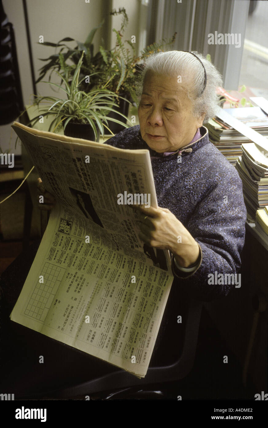 Eine Chinesin, lesen eine Zeitung, Birmingham UK Stockfoto