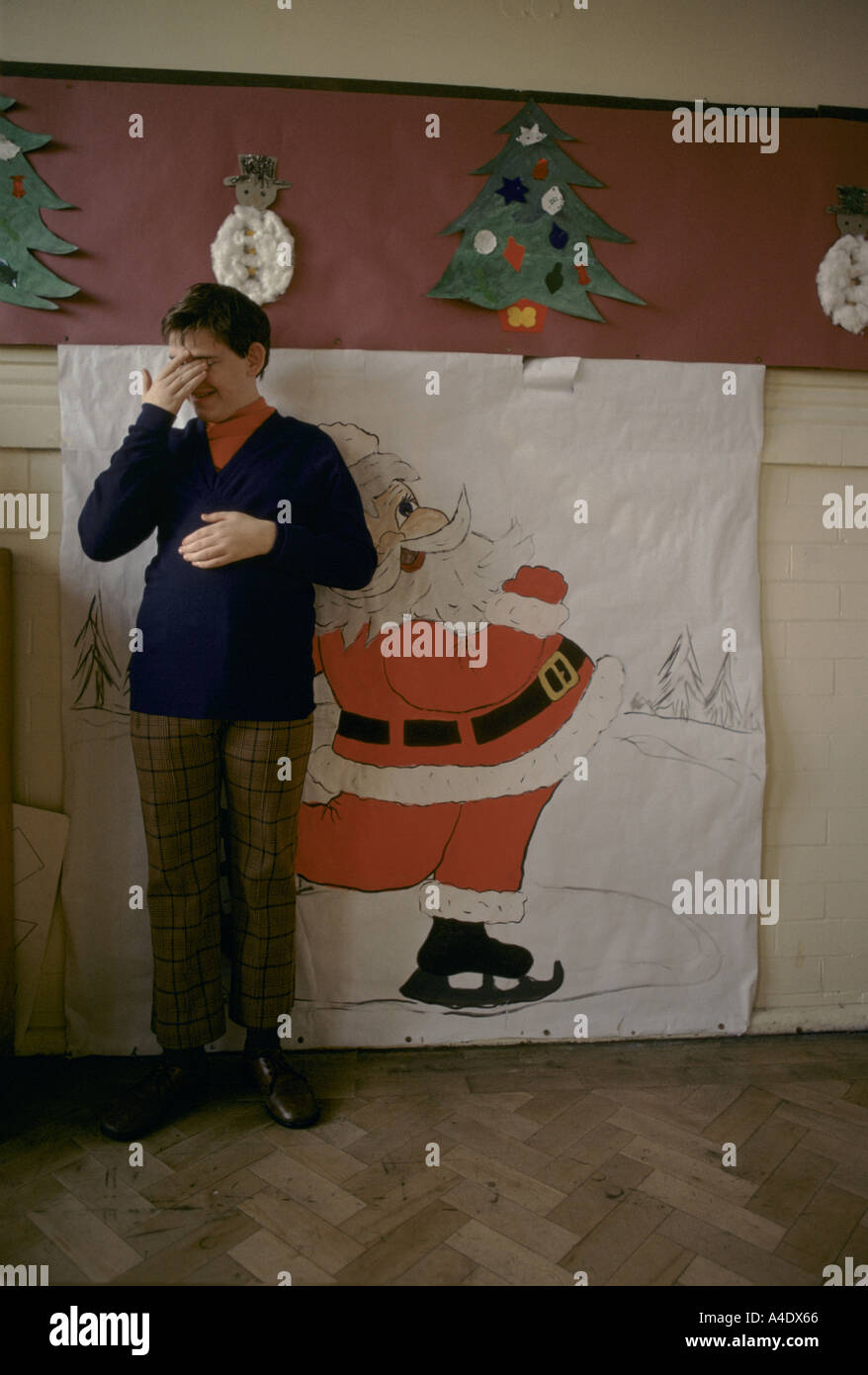 Geistig behindertes Kind in einem Heim mit Weihnachtsschmuck an der Wand Stockfoto