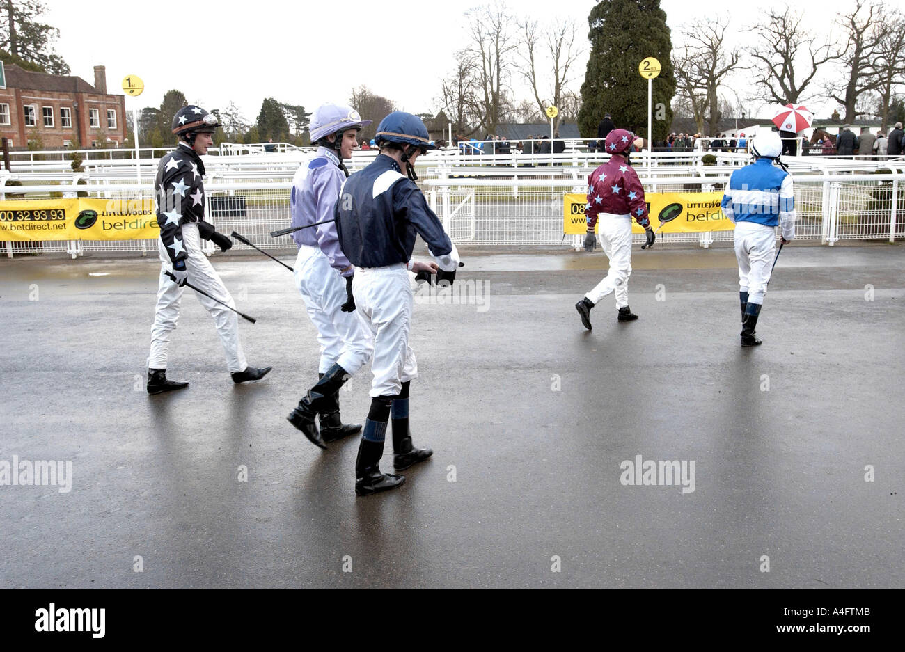 Jockeys ohne ihre Reittiere zu Fuß zu den Parade-Ring an einem Regenrennen Tag Stockfoto