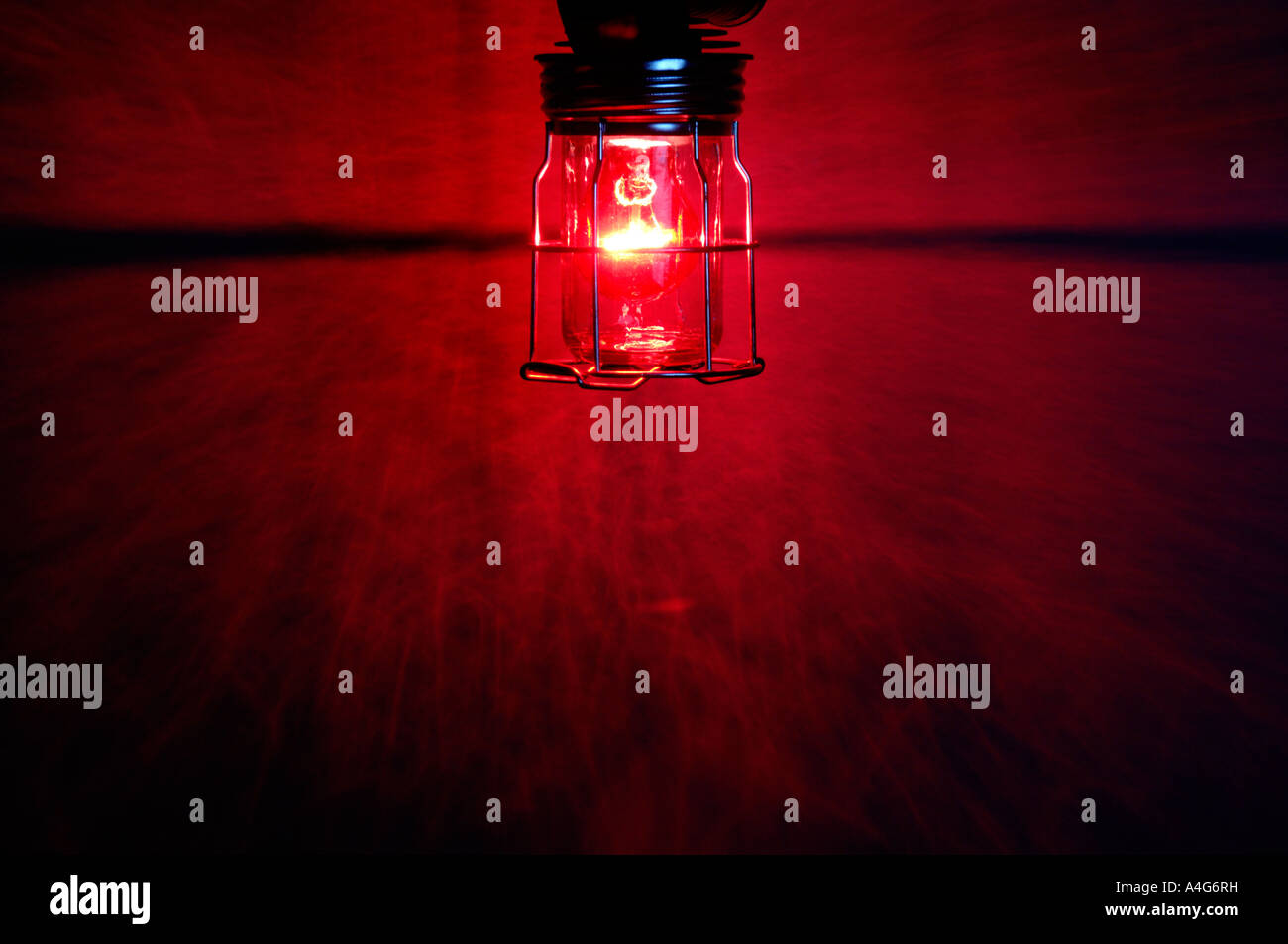 Rote Glühbirne in eine schützende Lampenhalter Stockfoto