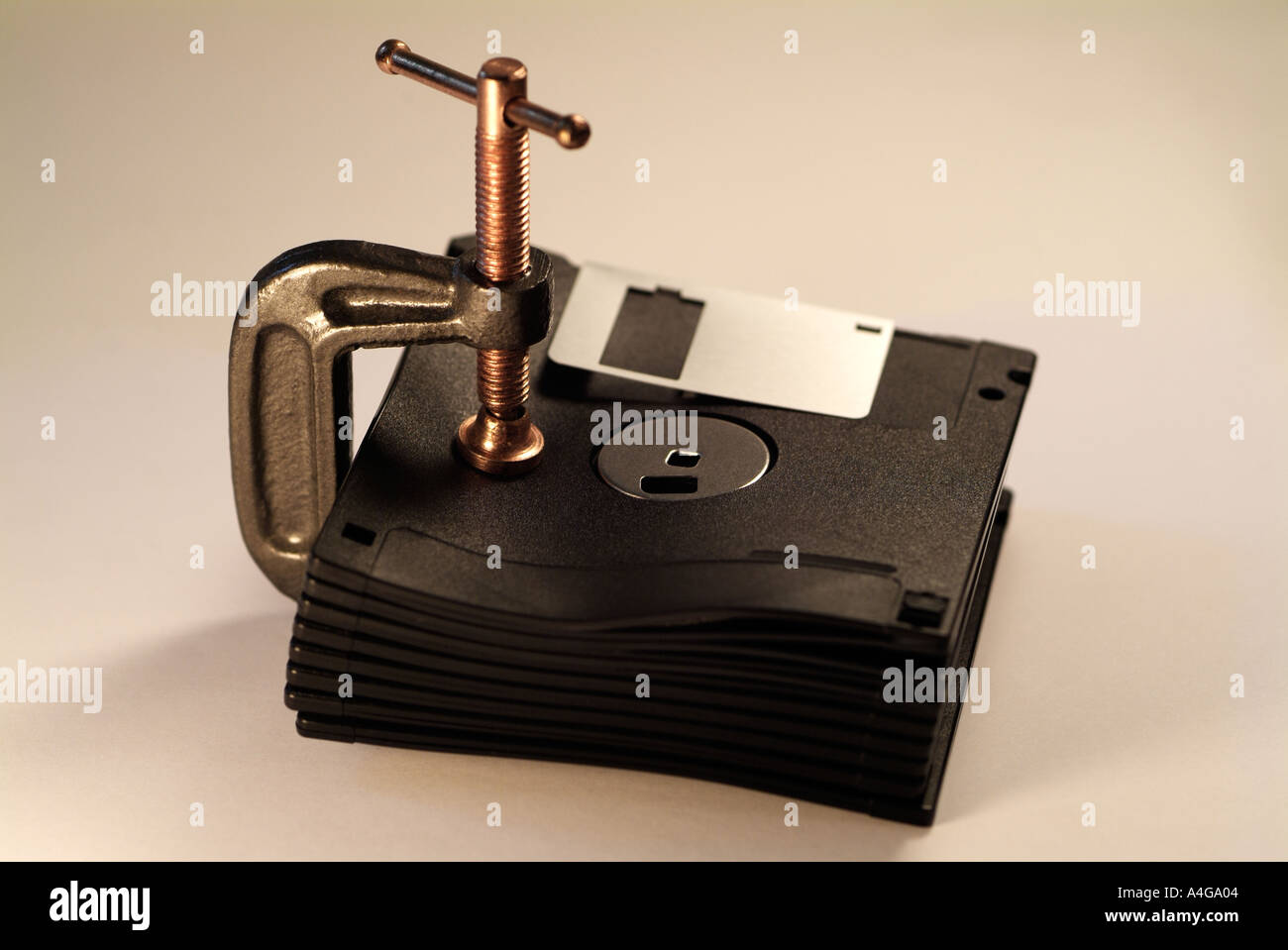 Datenkompression und Stauraum-Konzept zeigt Computer Floppy-Disks, die mit einer Klammer zusammen komprimiert Stockfoto