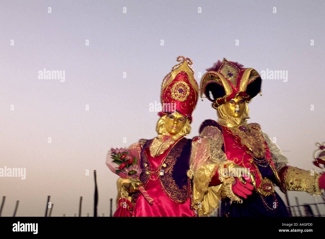 Gemeinsam zu zweit gekleidet in hellen Kostümen und gold Gesichtsmasken für die jährliche Maskerade-Karneval in Venedig Italien Stockfoto