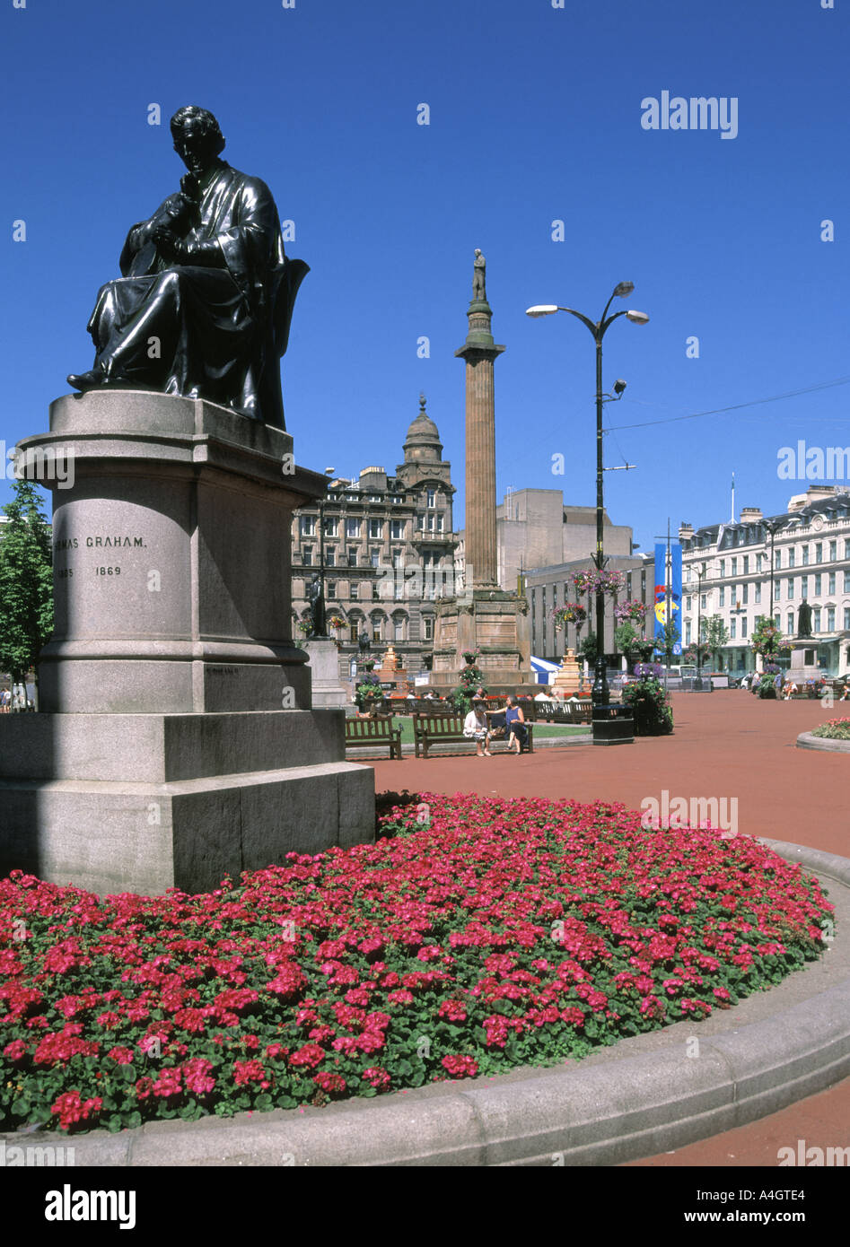 Historischer George Square Glasgower Blumen & Statue des Chemikers Dr Thomas Graham mit Sir Walter Scott Kolumne & historische Stadt Kammern über Schottland hinaus Großbritannien Stockfoto