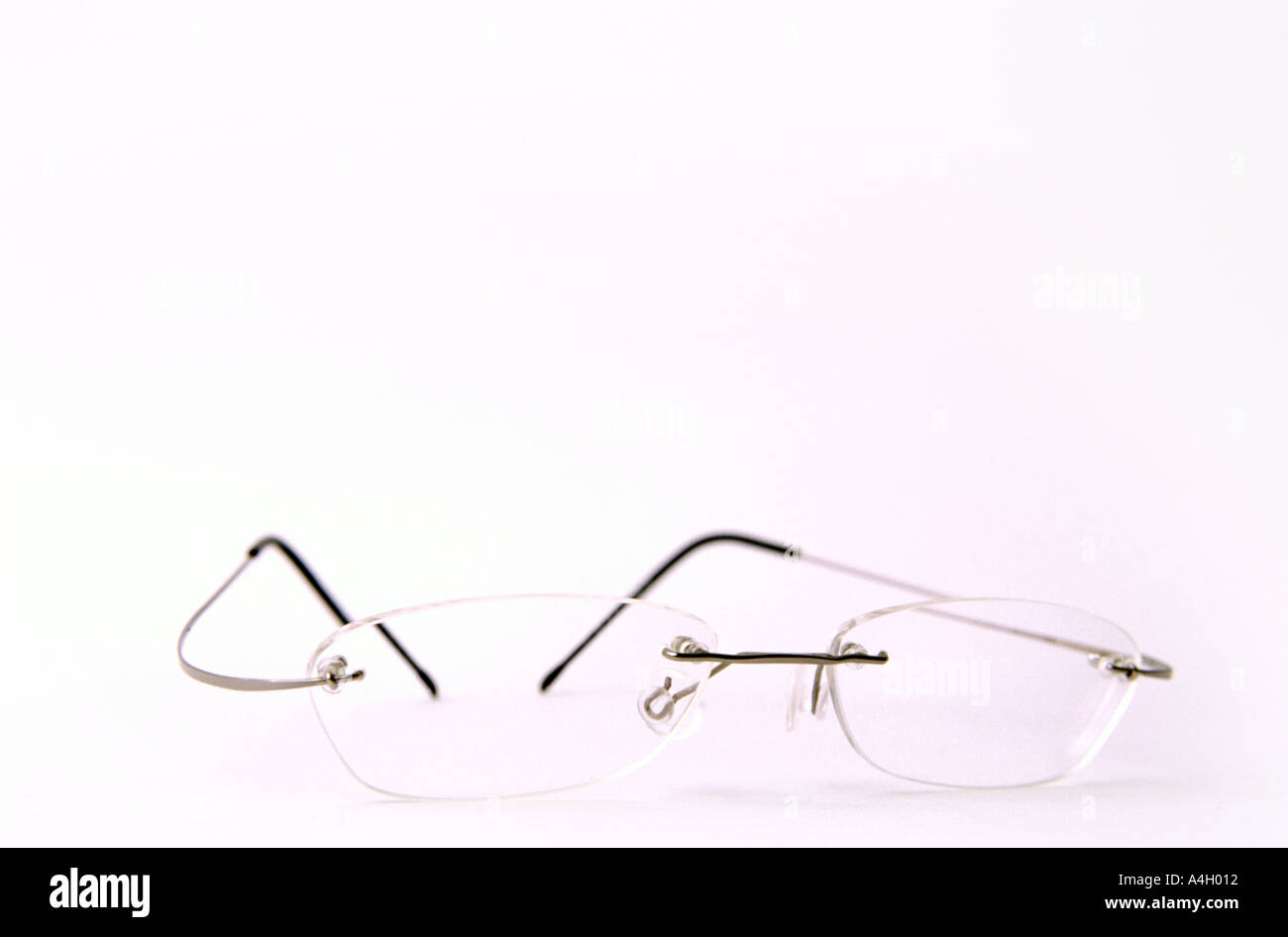 Dünne randlose Brille auf weißen Oberflächen high-key Stockfoto