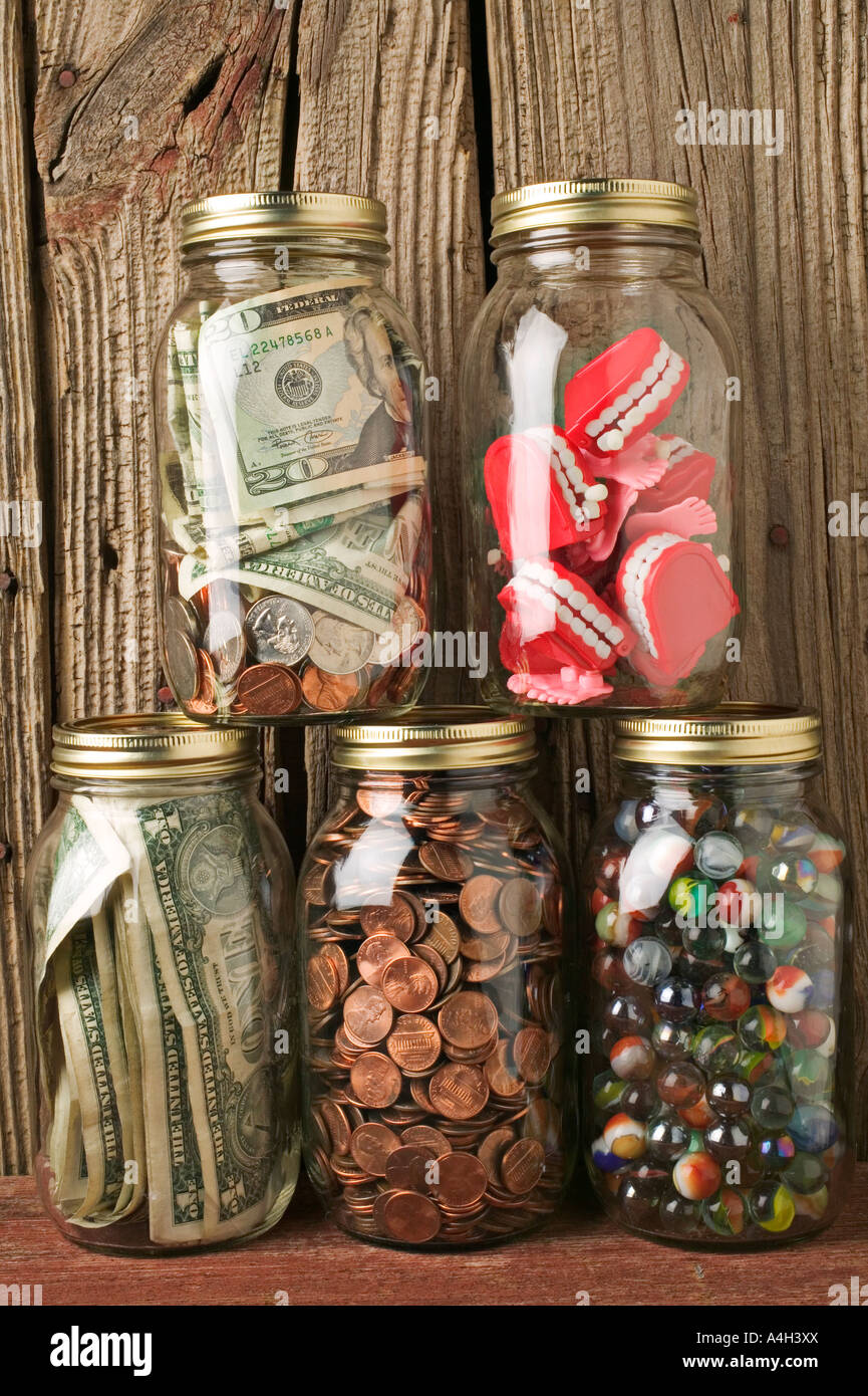Gläser voller Geld und Zähne Stockfoto