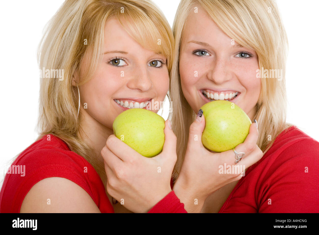 Zwei blonde Mädchen sind grüne Äpfel essen: (v. l. TR Modelle: Cassandra Müllner, Aileen Glahmann) Stockfoto