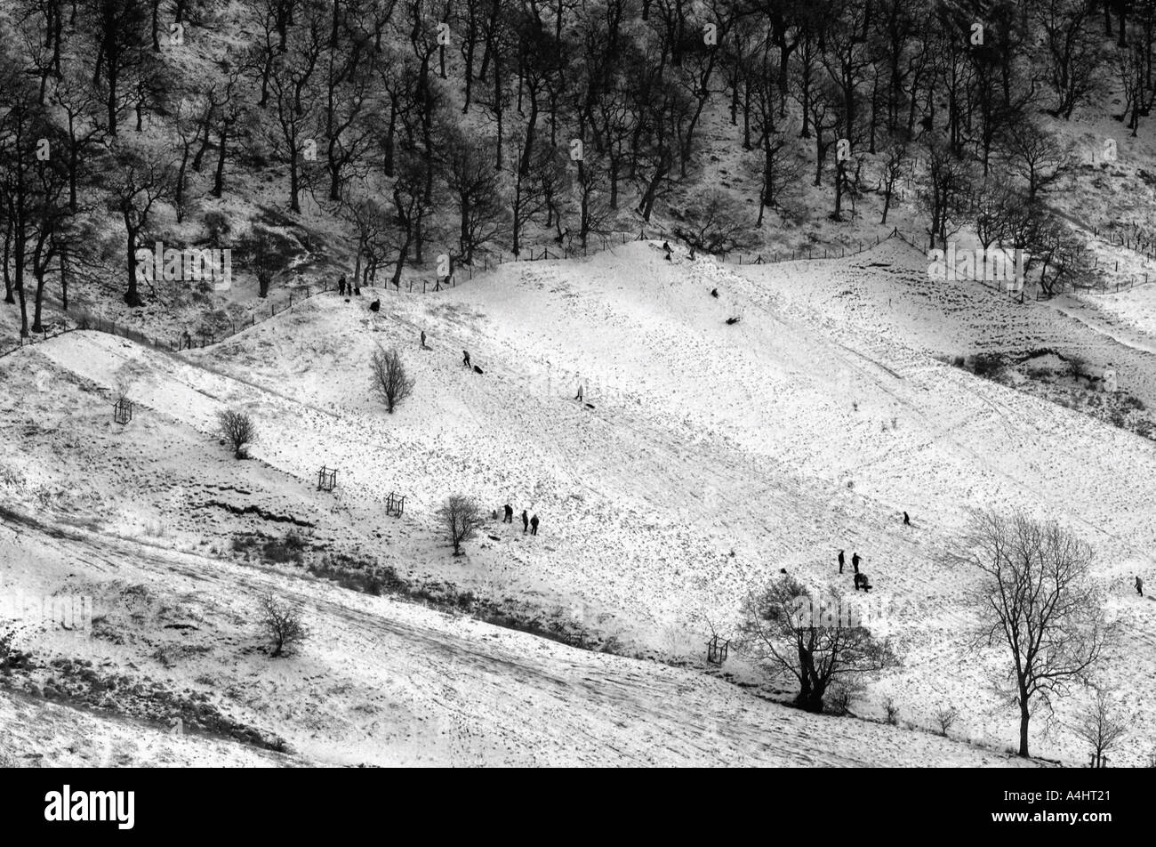 Familien in Ferne genießen einen Tag im Schnee North Yorkshire Moors England Rodeln Stockfoto