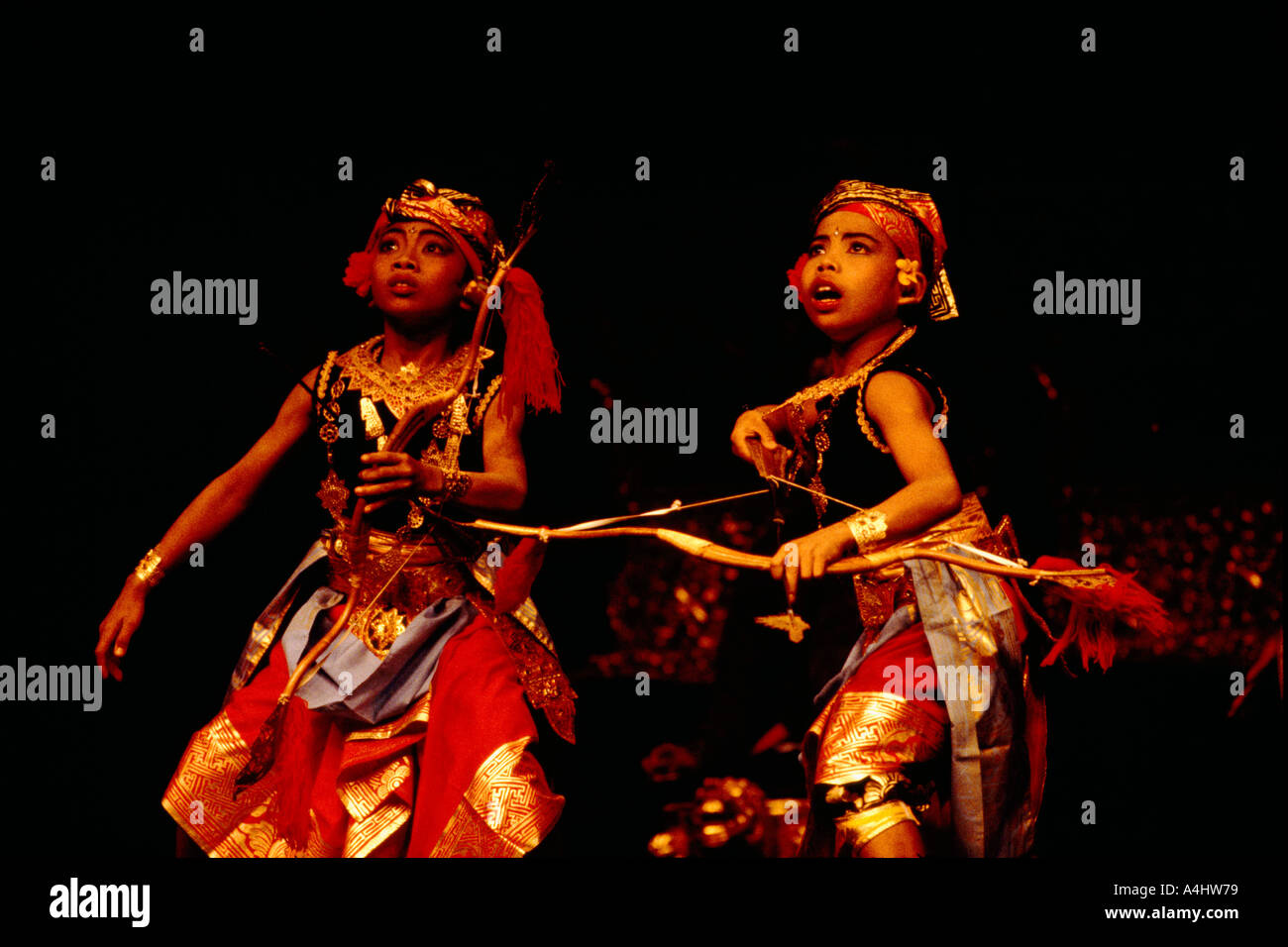 Balinesische Kleinkinder schießen Pfeil und Bogen im Bogenschießen-Tanz-Performance und tragen Tracht aus Indonesien Stockfoto