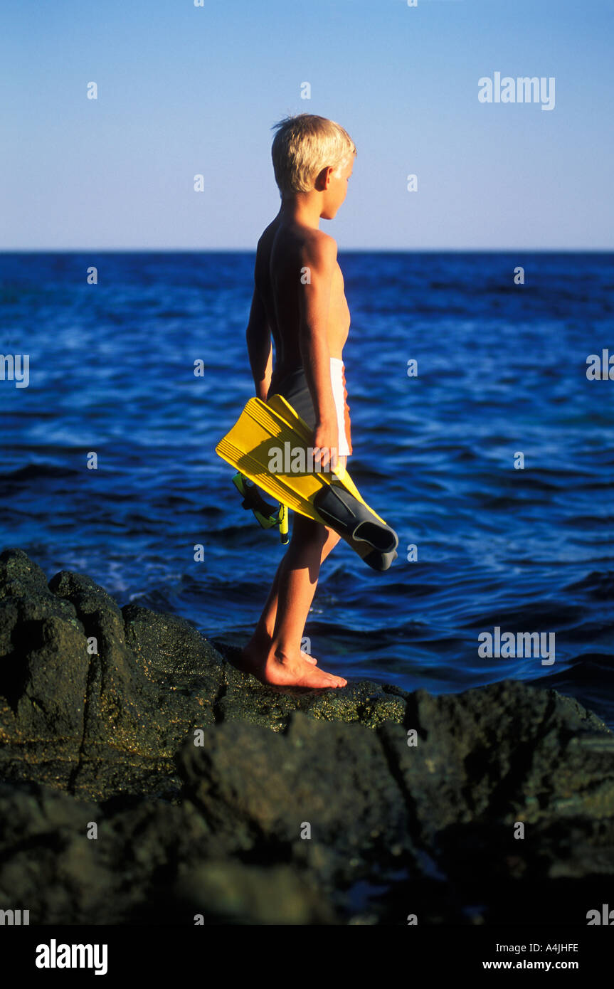 Junge mit flossen in seine Hände, Blick auf den Ozean Stockfoto