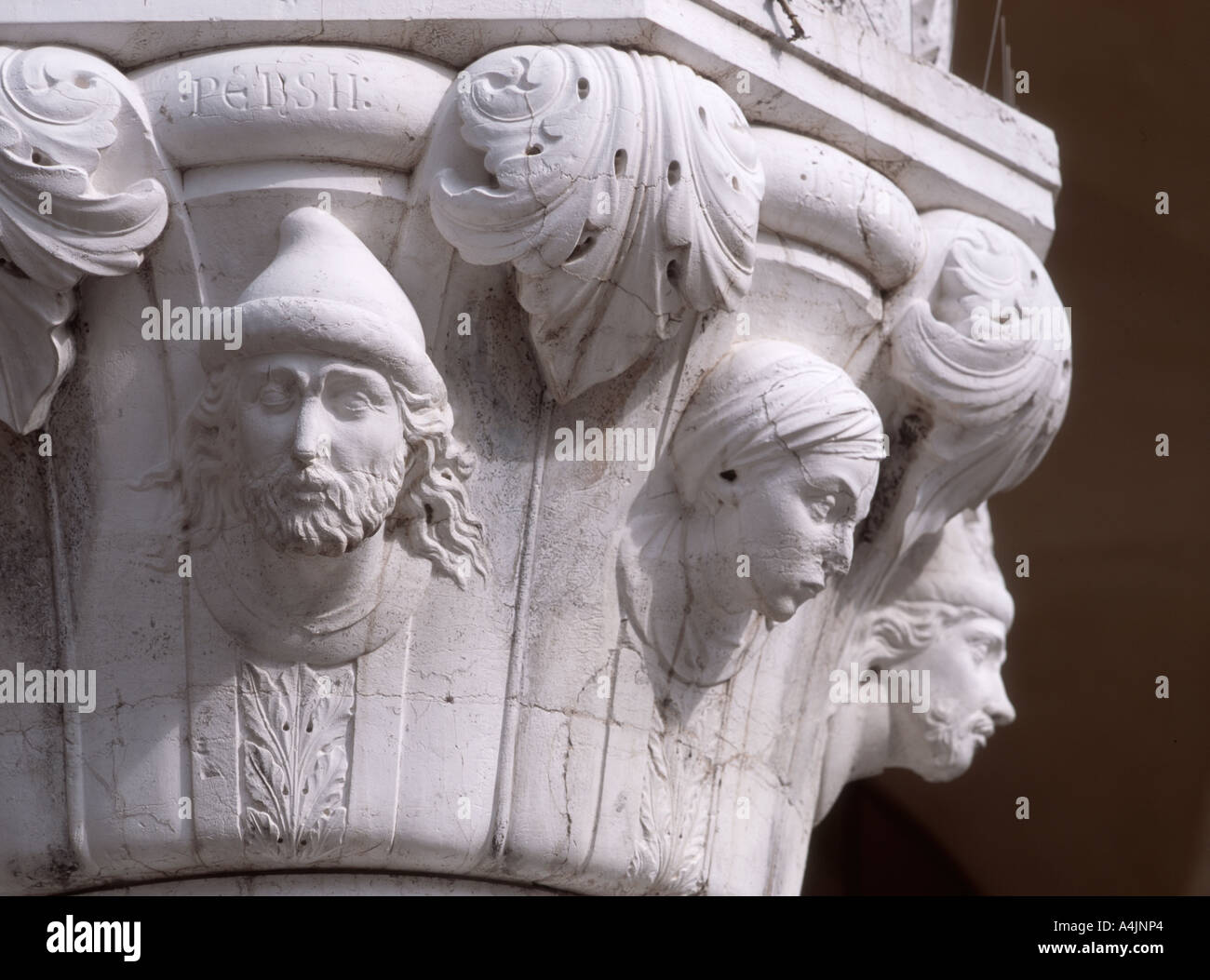 Venedig, Veneto, Italien. Geschnitzte Gesichter am oberen Rand einer Spalte auf der Westfassade der Dogenpalast Stockfoto