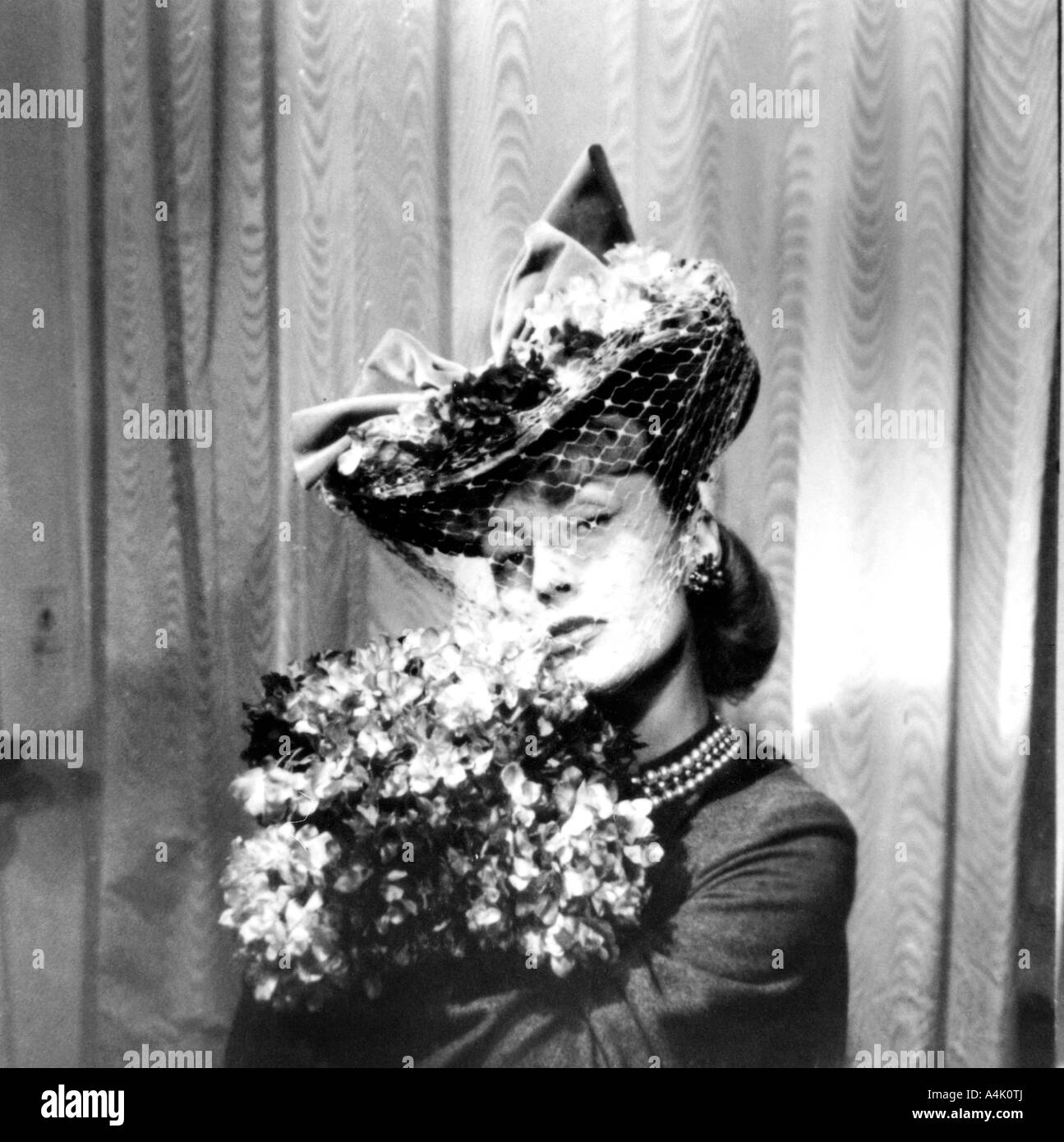 Frau mit Hut mit Schleier, mit einem Strauß Blumen, Paris, 1943. Artist: Unbekannt Stockfoto