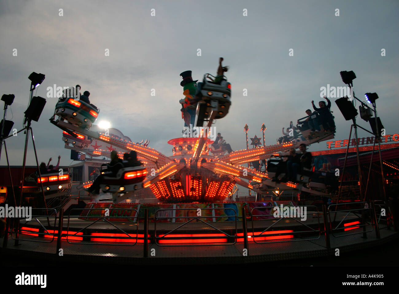 Beleuchtete Kirmes fahren in der Dämmerung Stockfoto