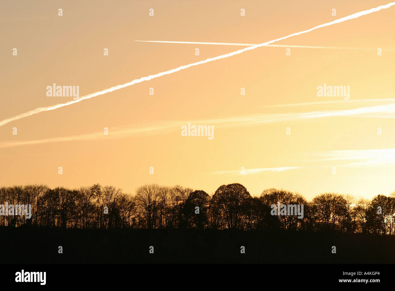 Vapor Trails im Himmel bei Sonnenuntergang Stockfoto