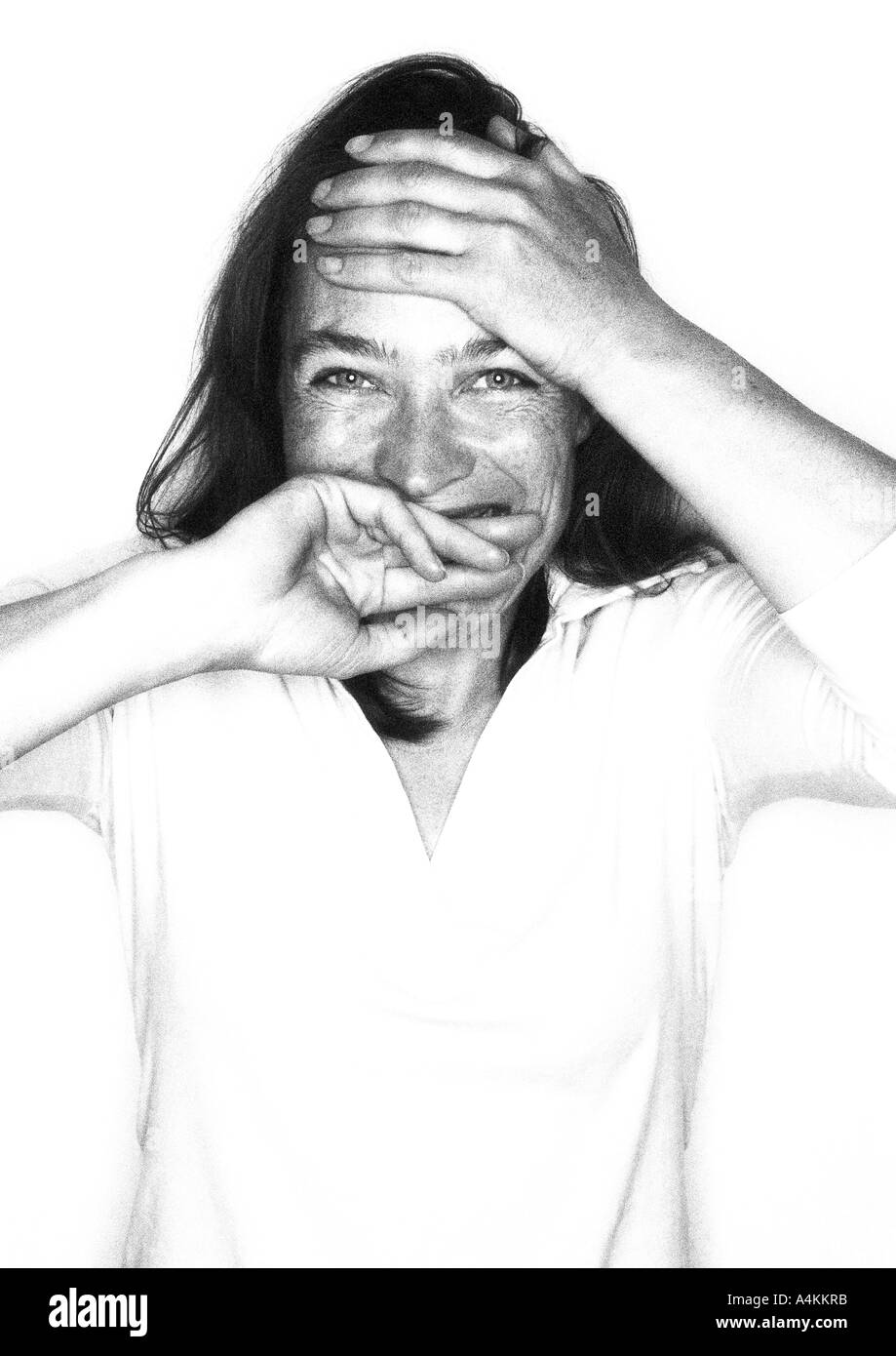 Frau lachend in die Kamera mit der Hand über Mund, Porträt Stockfoto