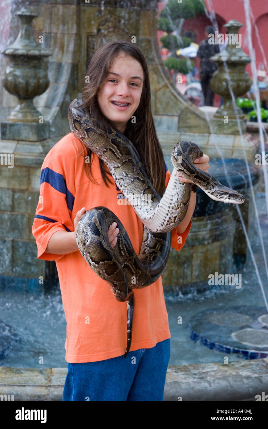 Eine langhaarige junge posiert für s Foto hält ein Python in Malacca Malaysia Stockfoto