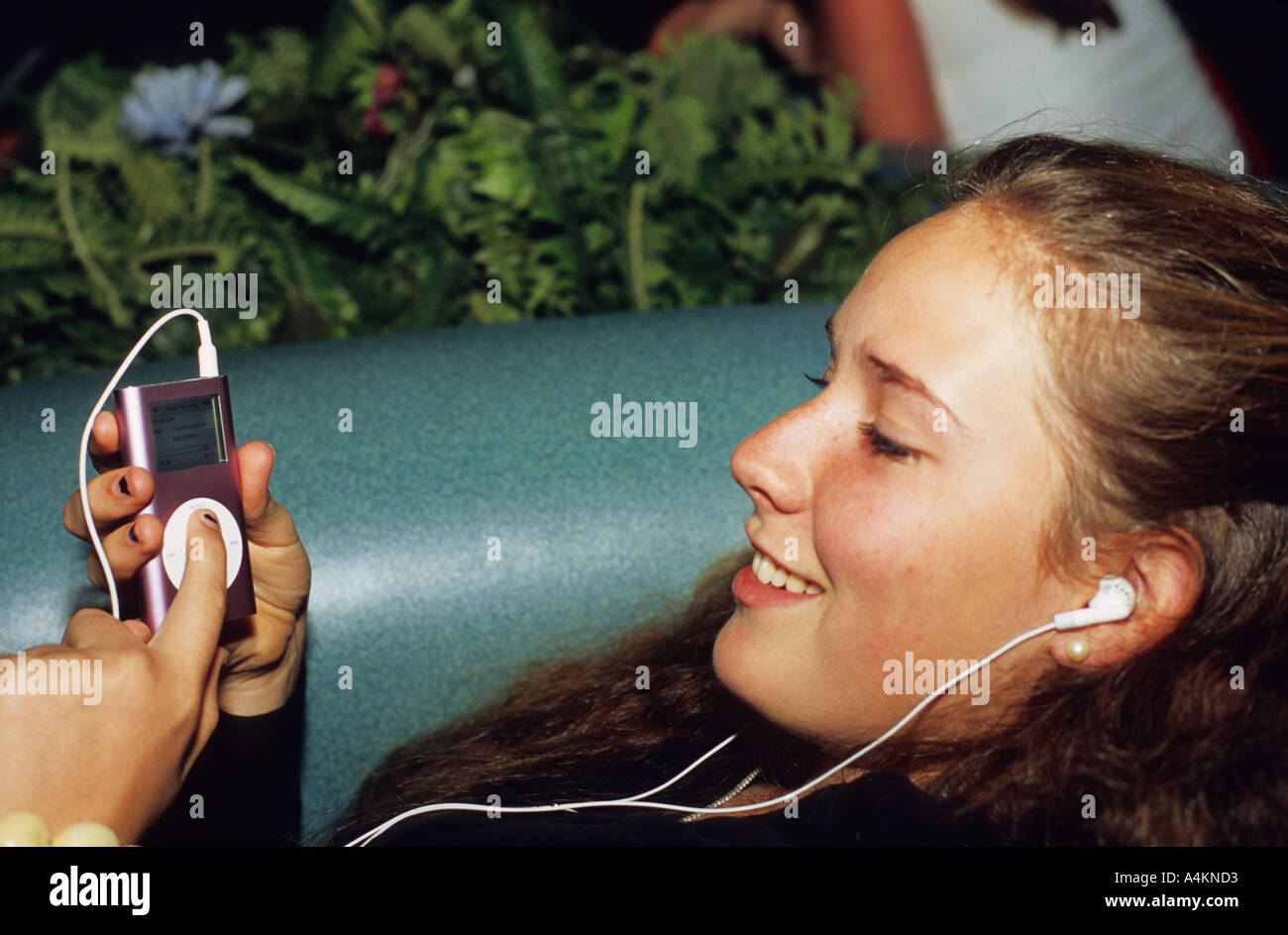Sechzehn Jahre alte weibliche Teenager einen iPod Mini MP3-Player anhören Stockfoto