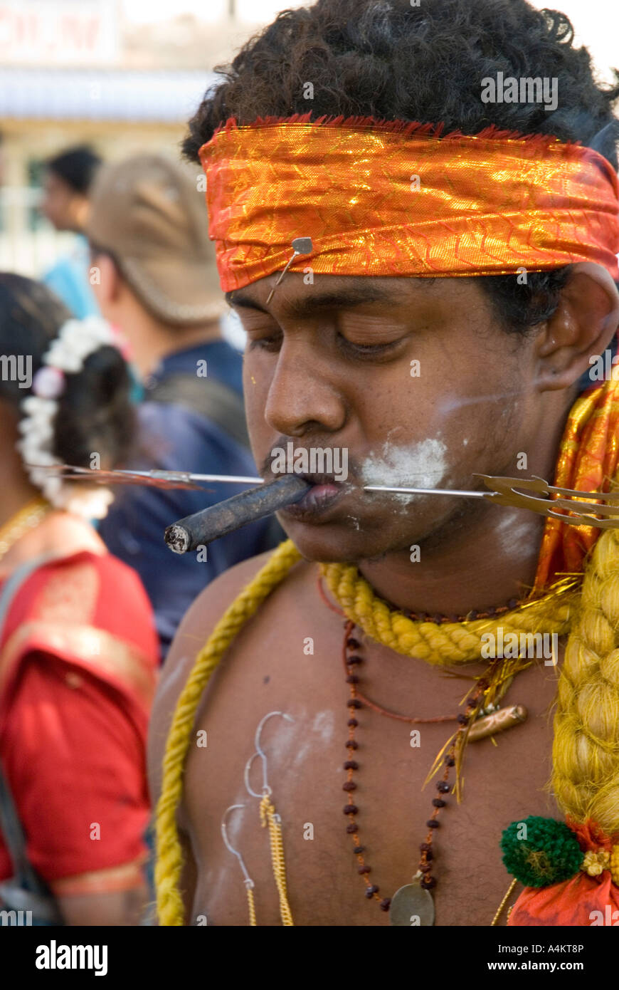 Malaysische Indianer feiern Thaipusam in Georgetown Penang. Ein Gläubiger raucht einen Cheroot mit durchstochenem Gesicht Stockfoto