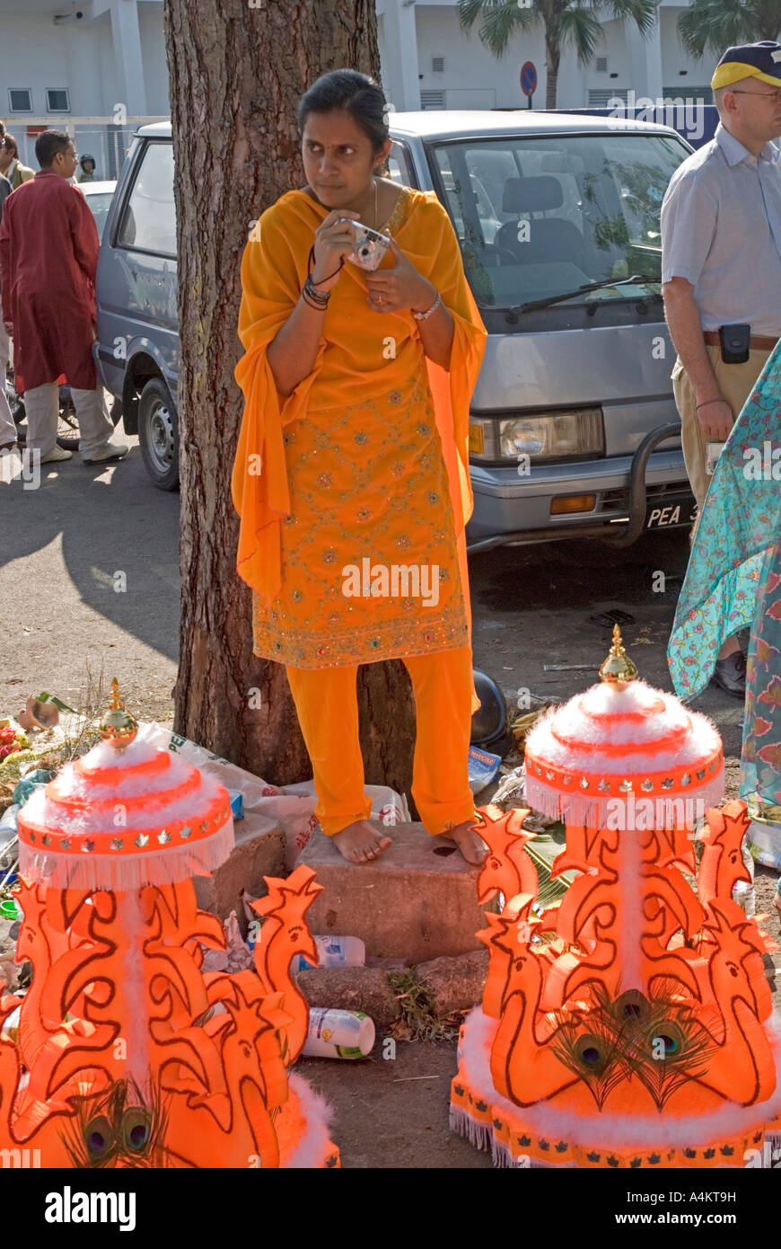 Frau in leuchtendem Orange gekleidet für die Feier von Thaipusam in Georgetown Penang Stockfoto