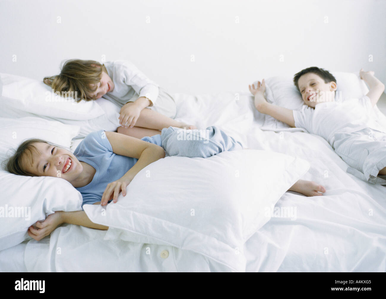Jungen und Mädchen auf Bett Lachen und Lächeln Stockfoto