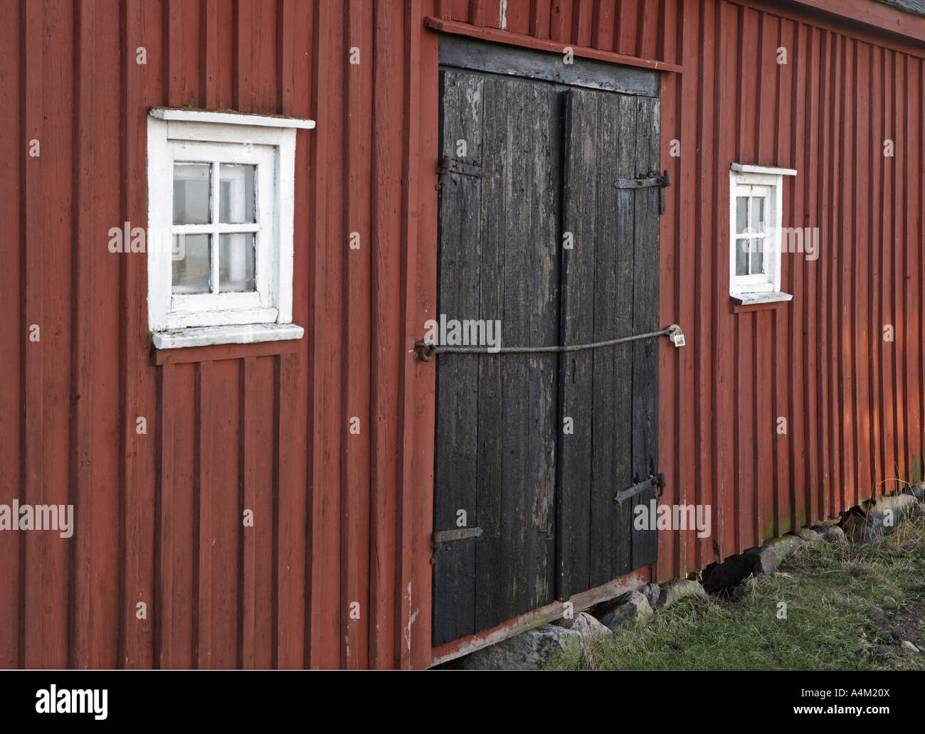 roten Holz Scheune mit weißen verglaste Fenster und Tür, schwarz Stockfoto