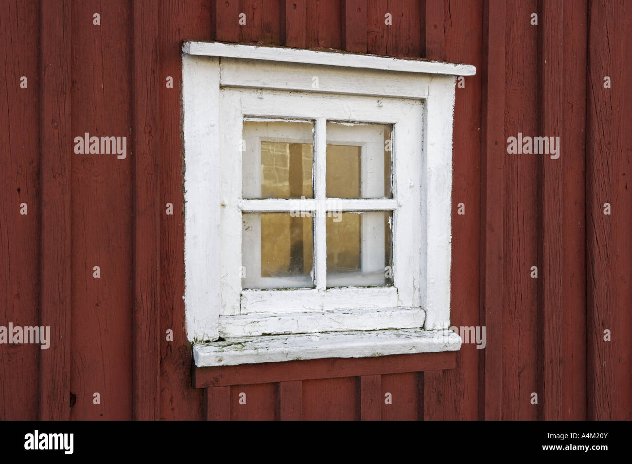Weißes verglaste Fenster im roten Holzhaus Stockfoto