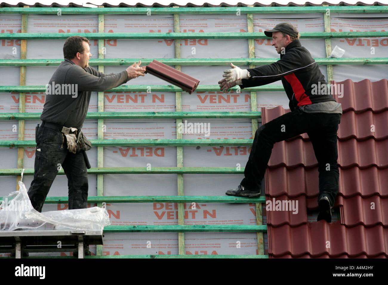 DEU-Deutschland-Essen-Fliesenleger arbeiten auf dem Dach eines Privathauses Dach Fenster Instalation Gebäudes einer Haus-Baustelle von Stockfoto