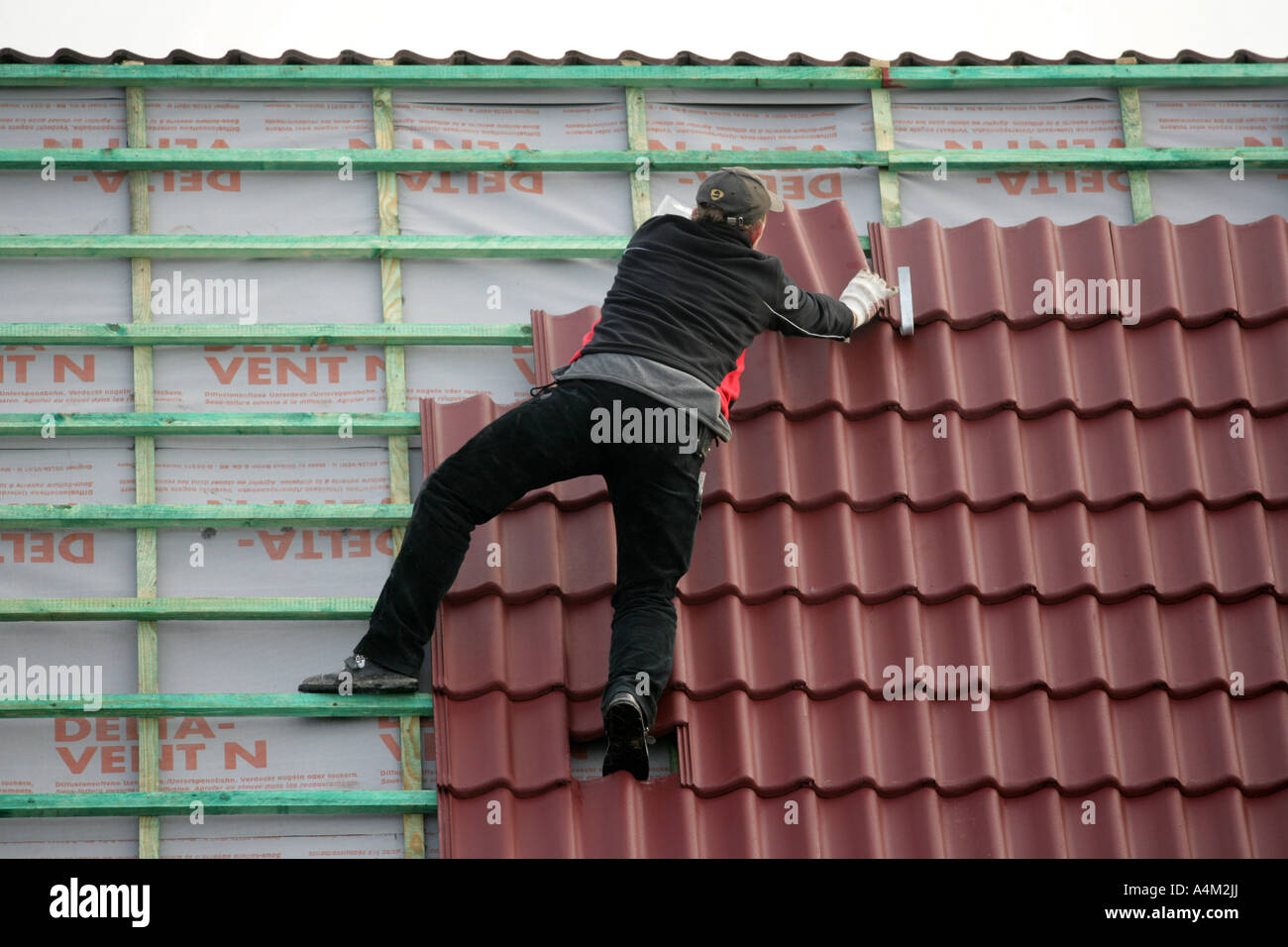 DEU-Deutschland-Essen-Fliesenleger arbeiten auf dem Dach eines Privathauses Dach Fenster Instalation Gebäudes einer Haus-Baustelle von Stockfoto
