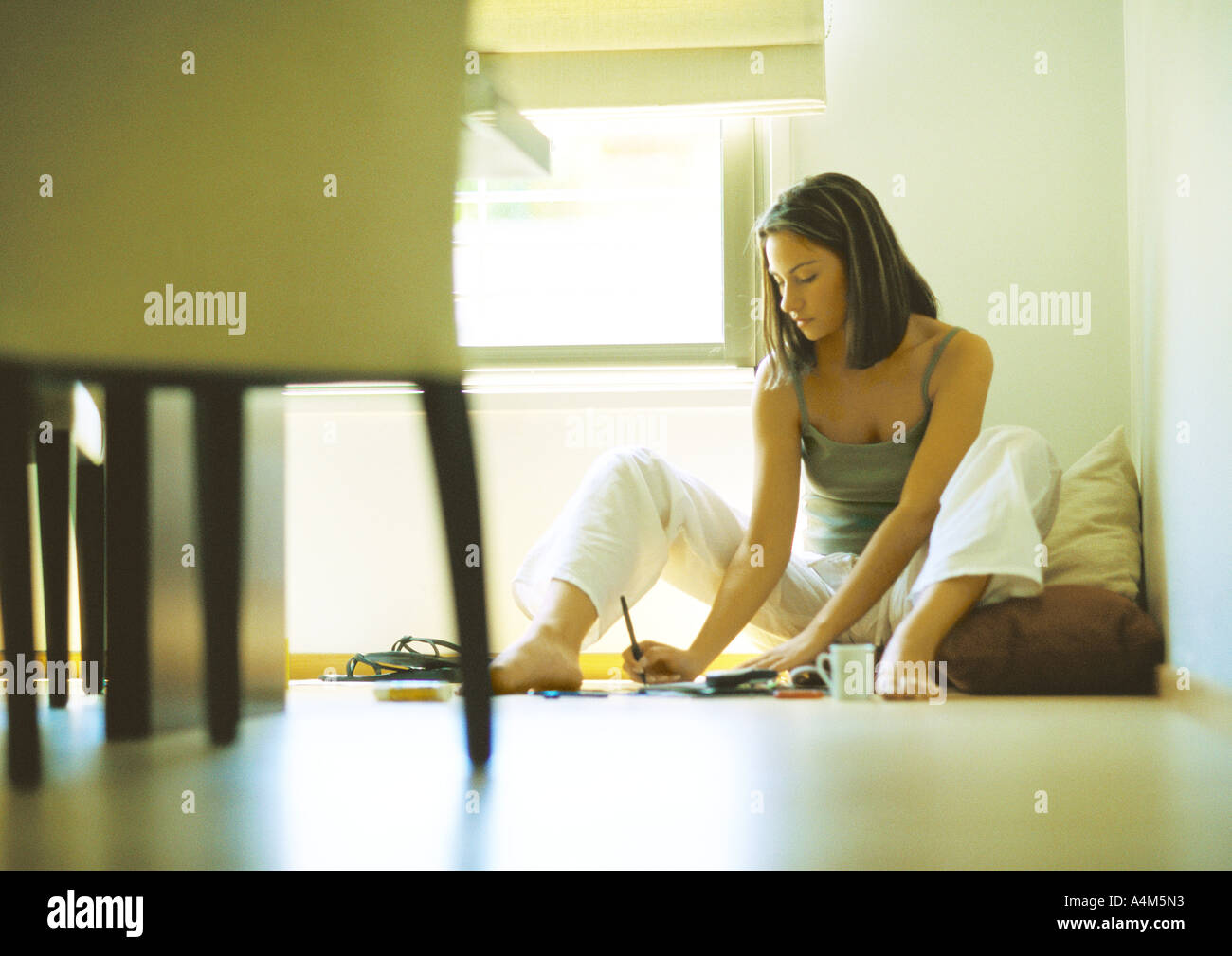 Frau sitzt am Boden, schreiben Stockfoto