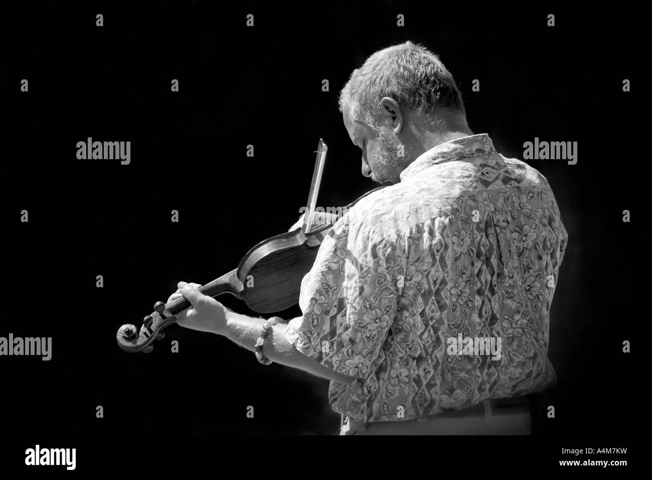 Ein junger Mann, der Violine oder eine Geige zu spielen. Stockfoto