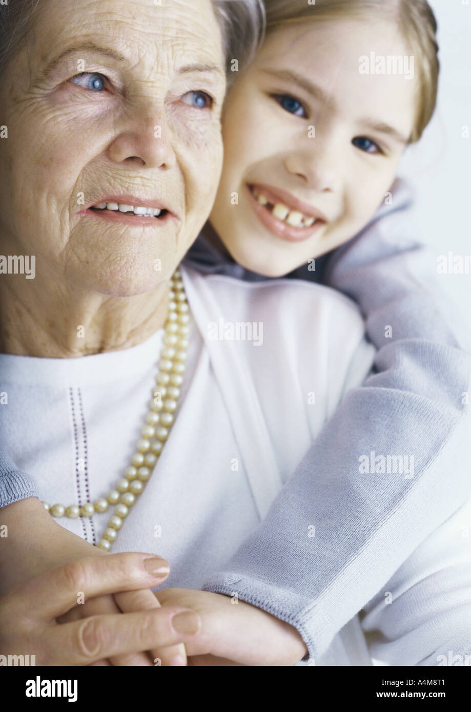 Mädchen umarmen Großmutter, portrait Stockfoto