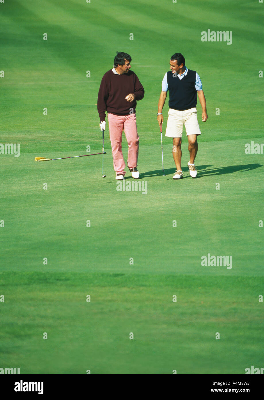 Zwei Golfer zu Fuß am Golfplatz Stockfoto